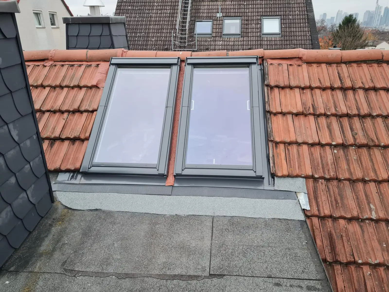 Zwei Fenster auf einem Dach mit Ziegeldach.