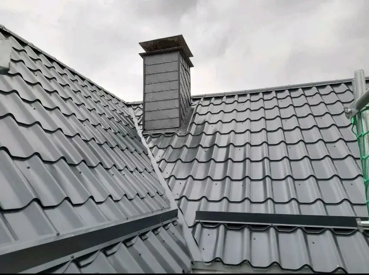 Ein Metalldach mit Kamin und Dachrinnen.