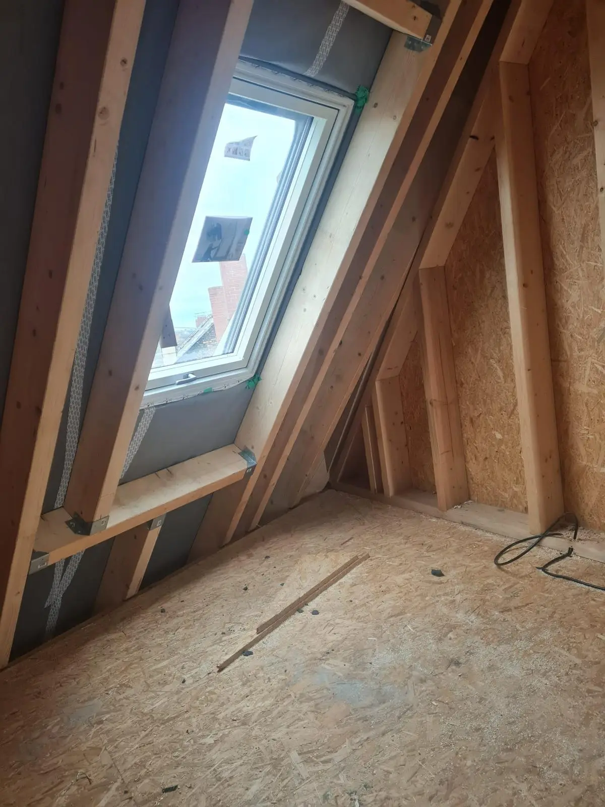 Ein Dachboden mit Holzboden und Dachfenster.
