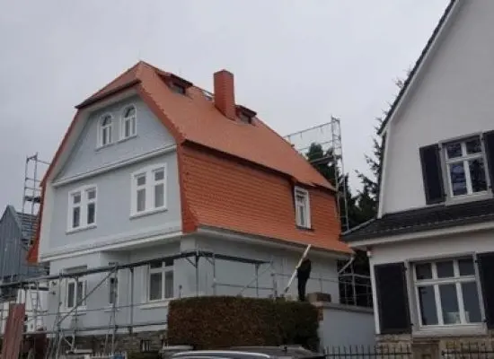 Ein im Bau befindliches Haus mit einem davor geparkten Auto.