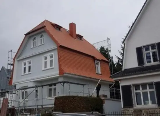 Ein im Bau befindliches Haus mit einem davor geparkten Auto.