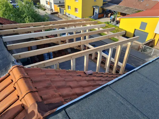 Auf einem Haus wird ein Dach gebaut.