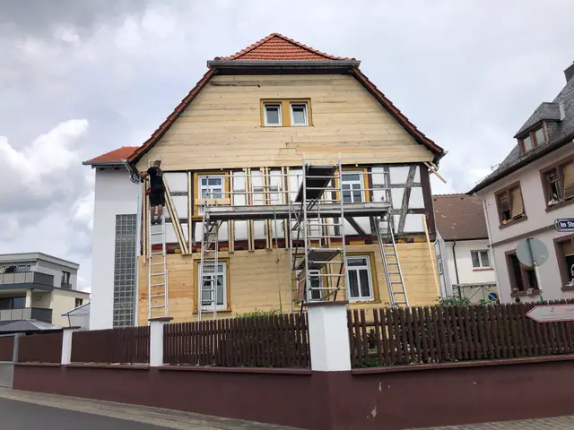 Es wird ein Haus gebaut, das von einem Gerüst umgeben ist.