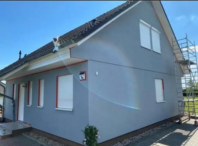 Ein Haus wird grau gestrichen.