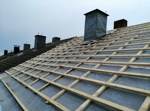 Auf einem Haus wird ein neues Dach installiert.