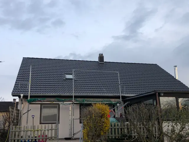 Ein Haus mit einem Dach, das neu gedeckt wird.