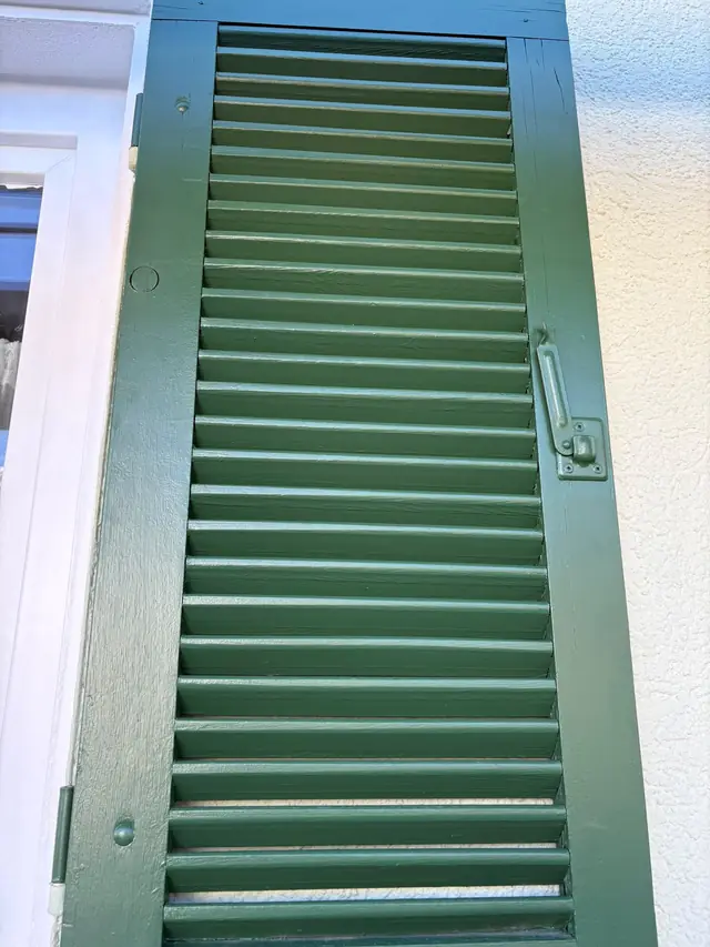 Derselbe Fensterladen, neu in Grün gestrichen.