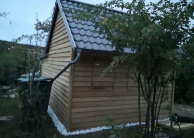 Ein kleiner Holzschuppen mit Dach.