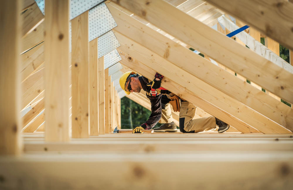Ein Bauarbeiter arbeitet an einem Holzdach.